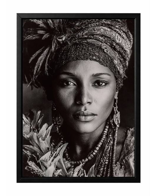 Black and white African-inspired woman portrait with patterned headwrap, feather detail, jewelry, and floral foreground.