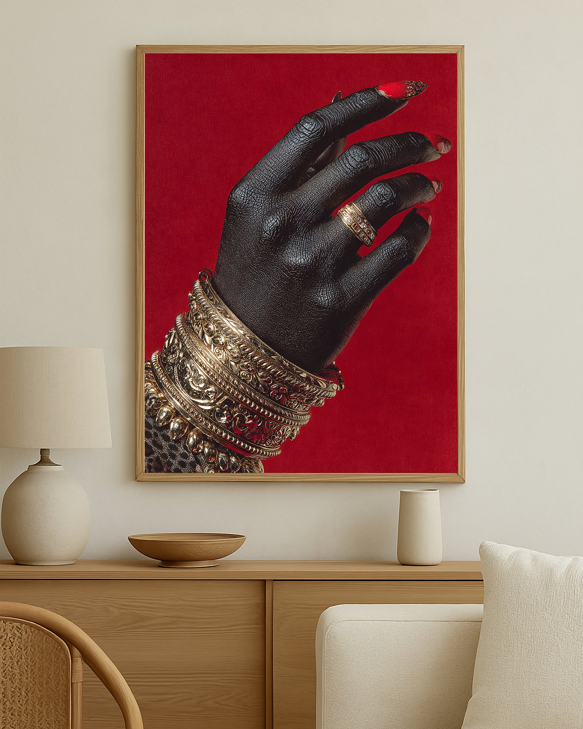 Luxury wall art print showing a close-up hand with gold bracelets and ring set against a bold rich red backdrop