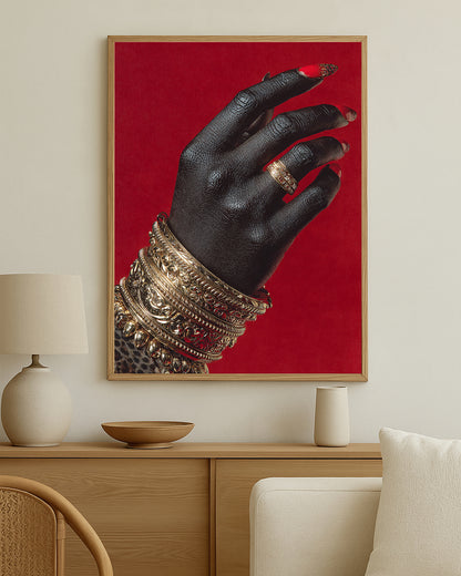 Luxury wall art print showing a close-up hand with gold bracelets and ring set against a bold rich red backdrop