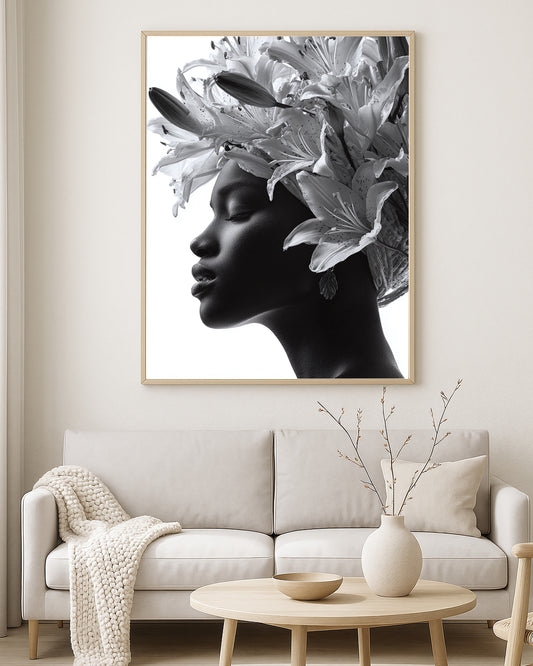 Monochrome portrait artwork of a woman with closed eyes surrounded by oversized lily flowers against a soft light background