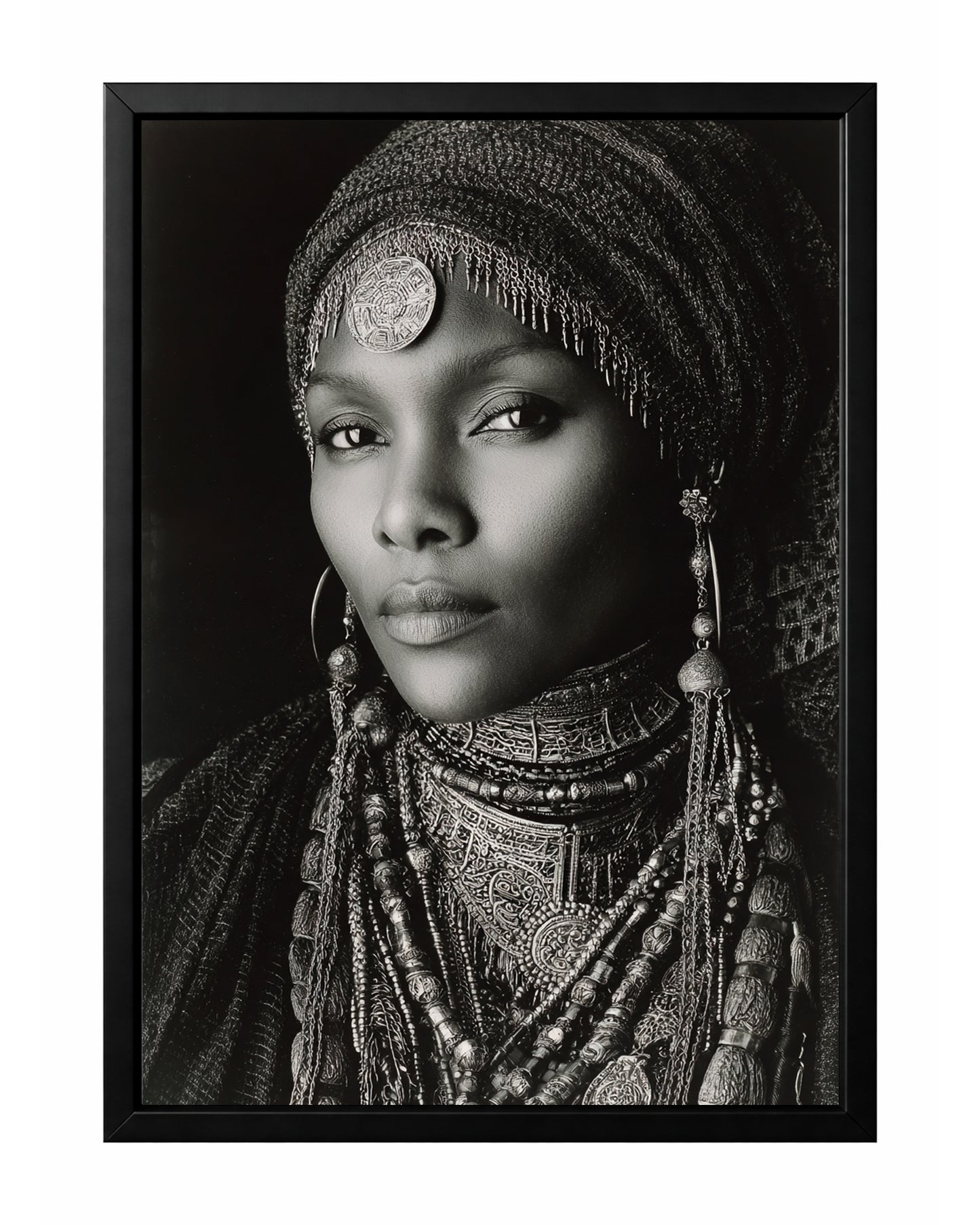 Monochrome African-inspired woman portrait with ornate head covering, layered jewelry, and direct gaze.