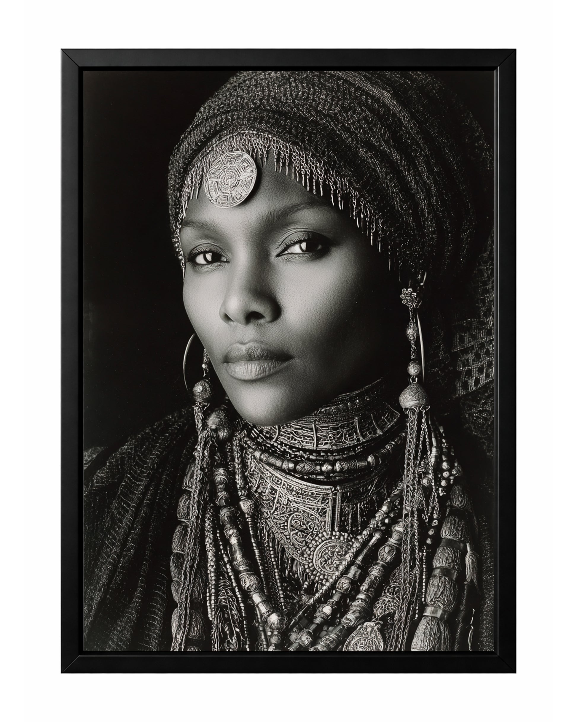 Monochrome African-inspired woman portrait with ornate head covering, layered jewelry, and direct gaze.